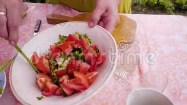 女人拖着一把刀，盘子里的蔬菜。 她`做蔬菜沙拉。 不错的特写。